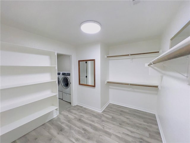 walk in closet featuring wood finished floors and separate washer and dryer