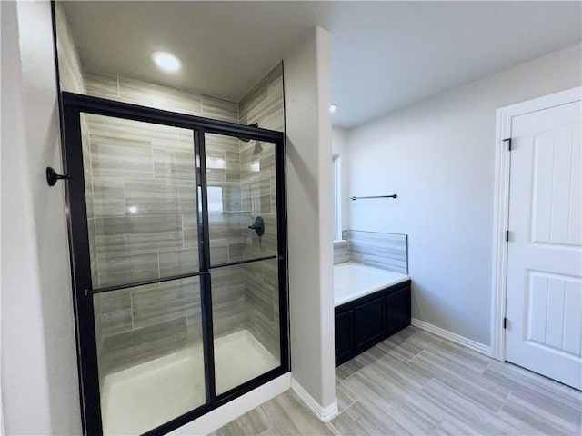 bathroom featuring a stall shower, baseboards, and a garden tub