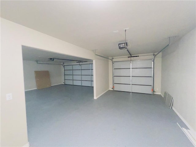 garage with a garage door opener, visible vents, and baseboards