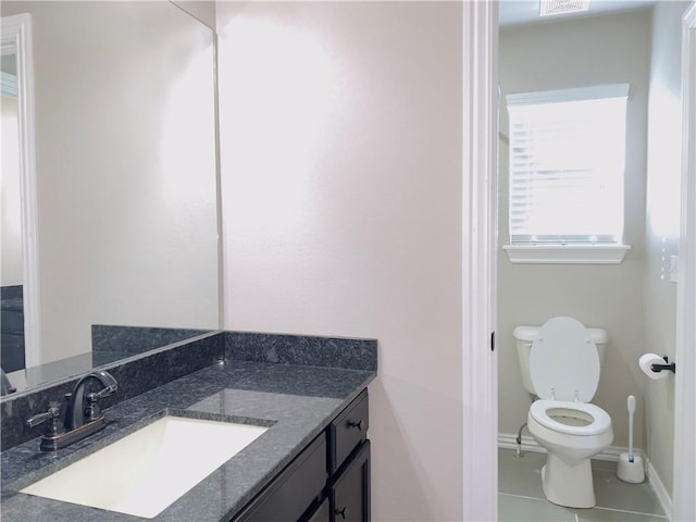 bathroom featuring toilet, tile patterned flooring, baseboards, and vanity