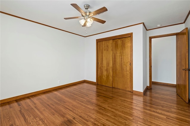 unfurnished bedroom with ornamental molding, a closet, baseboards, and wood finished floors