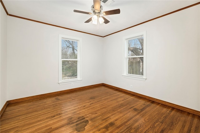 empty room with plenty of natural light, crown molding, baseboards, and wood finished floors