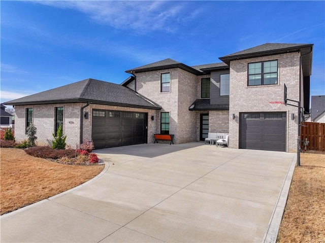 prairie-style home with a garage, brick siding, a shingled roof, fence, and driveway