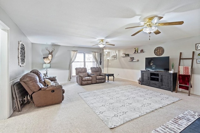 living area featuring ceiling fan, a textured ceiling, and carpet flooring