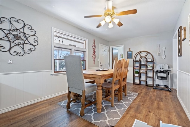 dining room featuring ceiling fan, wainscoting, and wood finished floors