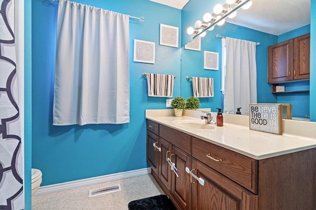 bathroom with toilet, baseboards, visible vents, and vanity