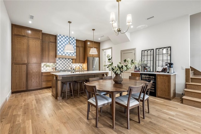 445 NW C St, Bentonville, AR 72712 - dining room with light wood-style floors, beverage cooler, stairs, recessed lighting, and a chandelier