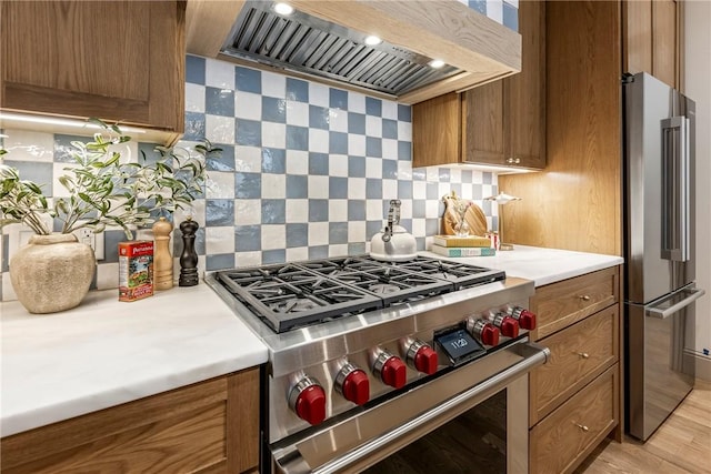 445 NW C St, Bentonville, AR 72712 - kitchen with appliances with stainless steel finishes, custom range hood, brown cabinetry, backsplash, and light countertops