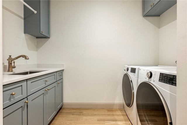 445 NW C St, Bentonville, AR 72712 - laundry room with cabinet space, washer and clothes dryer, and light wood finished floors