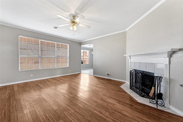 unfurnished living room featuring visible vents, a fireplace, baseboards, and wood finished floors