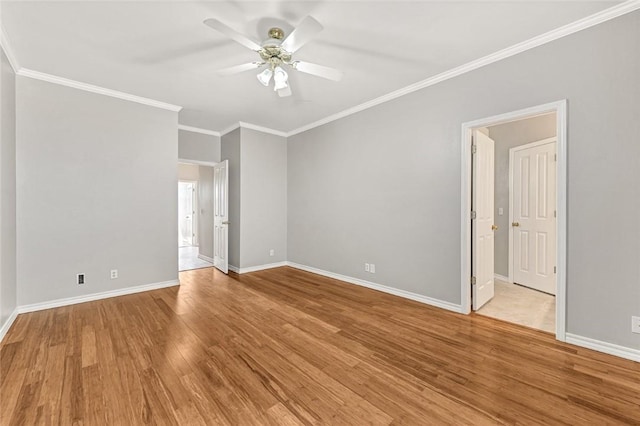 spare room with light wood-style floors, ornamental molding, baseboards, and a ceiling fan