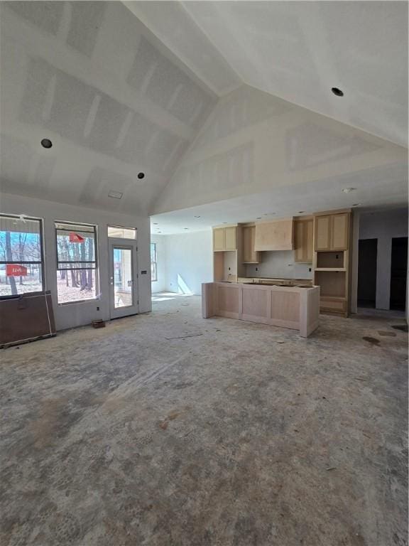 unfurnished living room with high vaulted ceiling