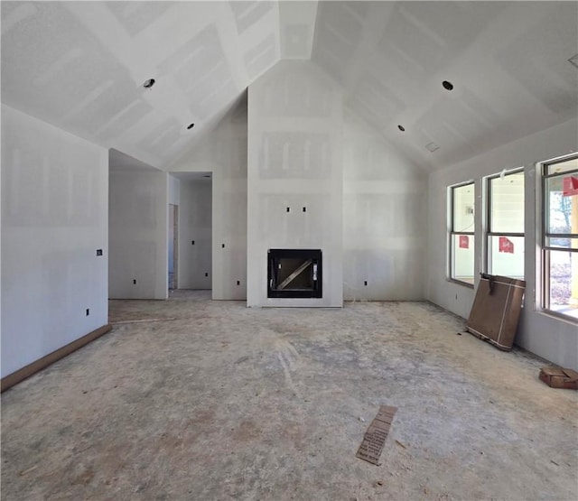 unfurnished living room featuring high vaulted ceiling, visible vents, and a glass covered fireplace