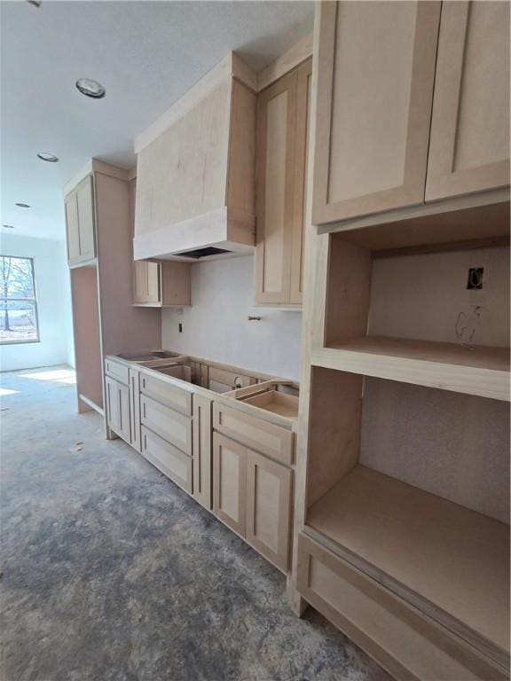 kitchen with cooktop, custom exhaust hood, and light brown cabinetry