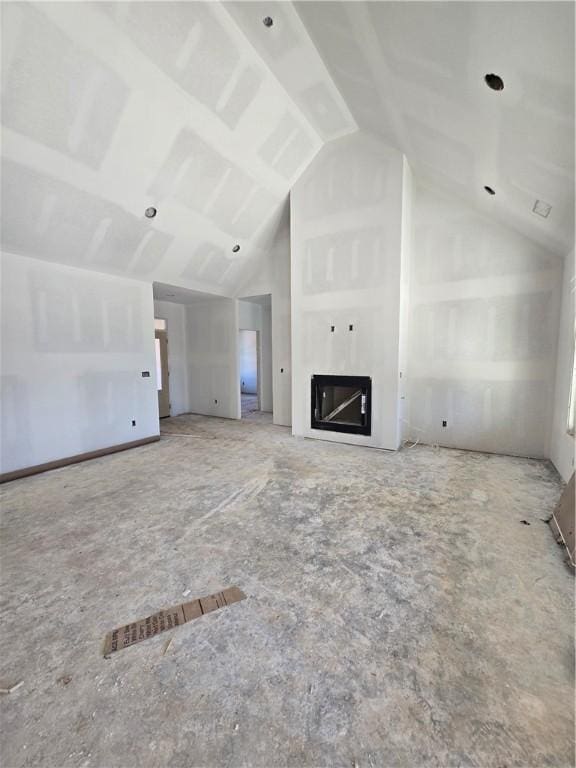 unfurnished living room with a glass covered fireplace and vaulted ceiling