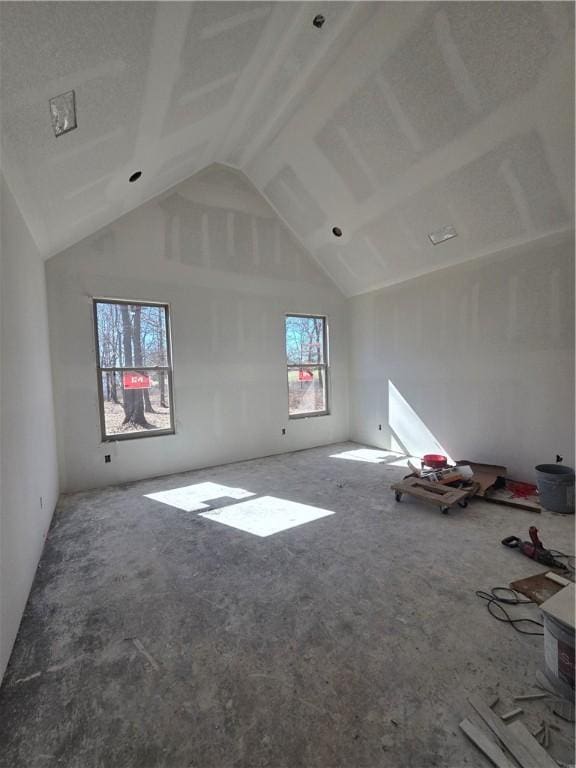 additional living space featuring high vaulted ceiling and carpet flooring