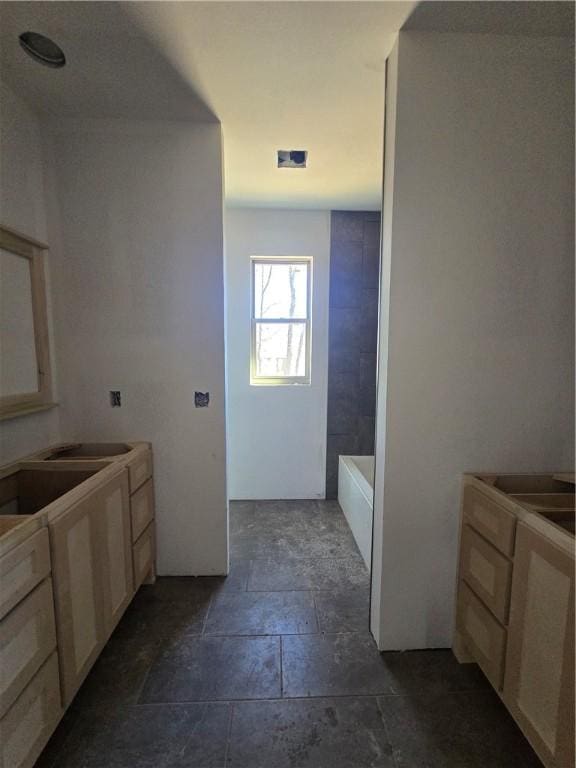 bathroom with a bathtub and stone tile flooring