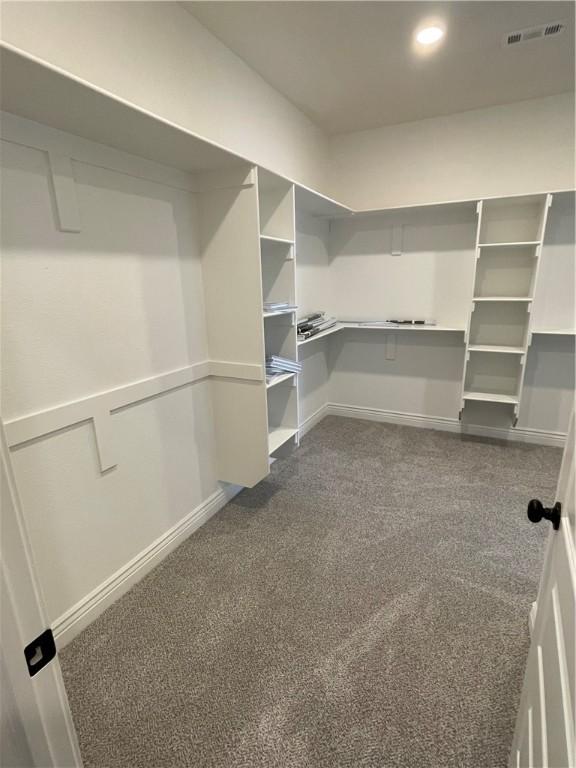 spacious closet with visible vents and dark carpet