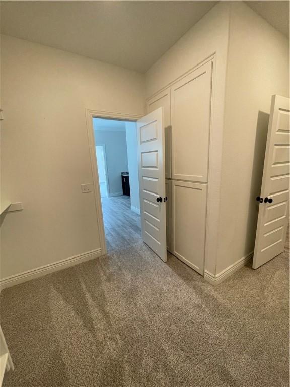 corridor with carpet flooring and baseboards