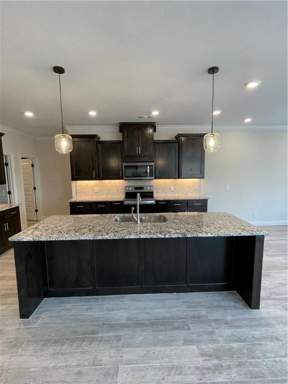 5 Burns Cir, Bella Vista, AR 72714 - kitchen featuring appliances with stainless steel finishes, a sink, ornamental molding, tasteful backsplash, and light stone countertops