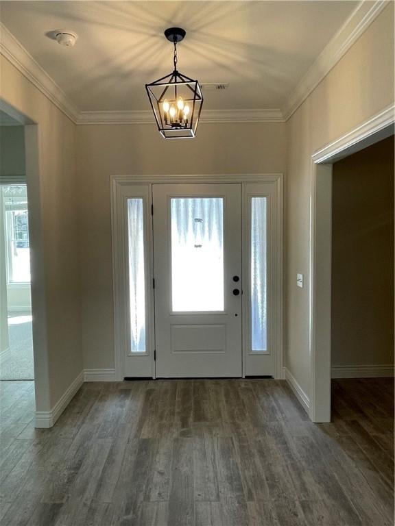 entrance foyer with a notable chandelier, baseboards, wood finished floors, and crown molding