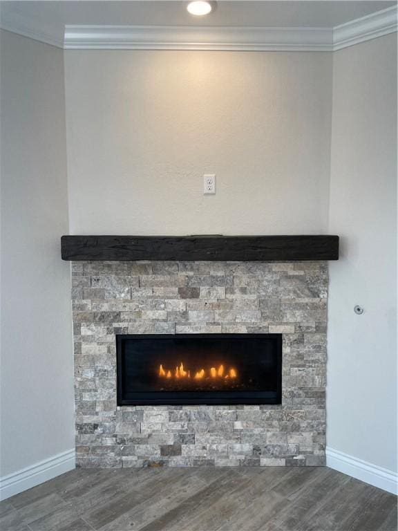 details with baseboards, a fireplace, wood finished floors, and crown molding