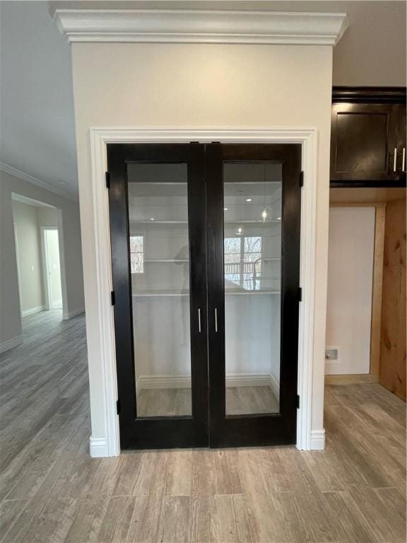 room details featuring ornamental molding, french doors, baseboards, and wood finished floors