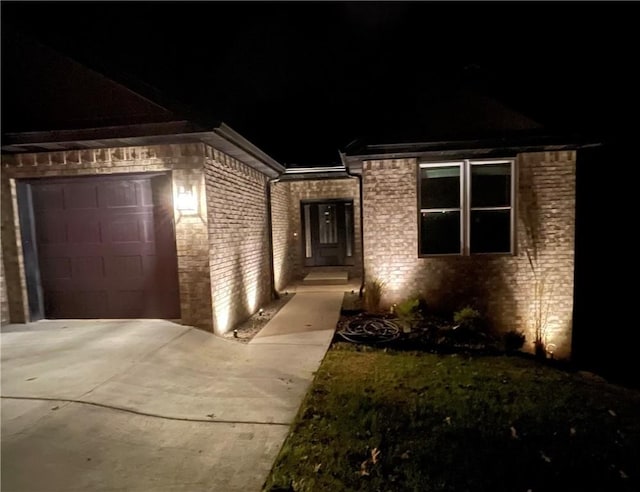 view of front of house featuring driveway, brick siding, and an attached garage