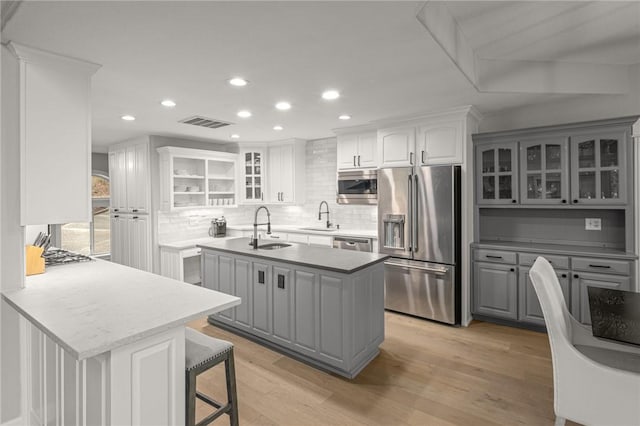 8354 Hopper Rd, Rogers, AR 72756 - kitchen featuring stainless steel appliances, gray cabinetry, backsplash, recessed lighting, and a kitchen breakfast bar