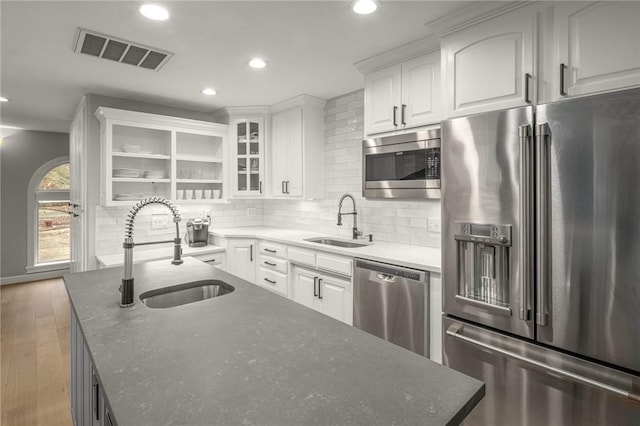 kitchen with visible vents, a sink, white cabinetry, and stainless steel appliances