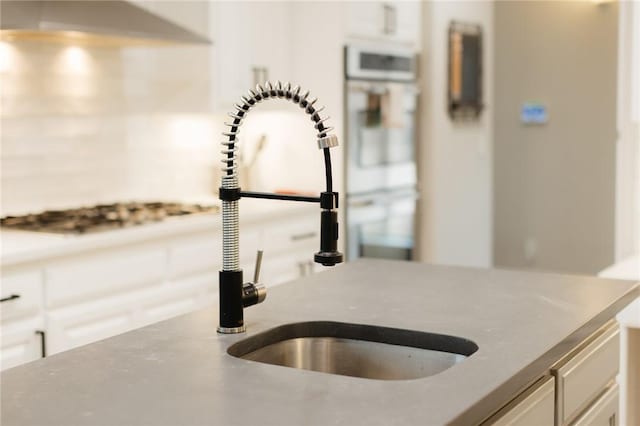 room details with white cabinetry and a sink