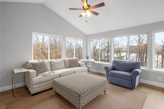 sunroom featuring baseboards, high vaulted ceiling, wood finished floors, and visible vents