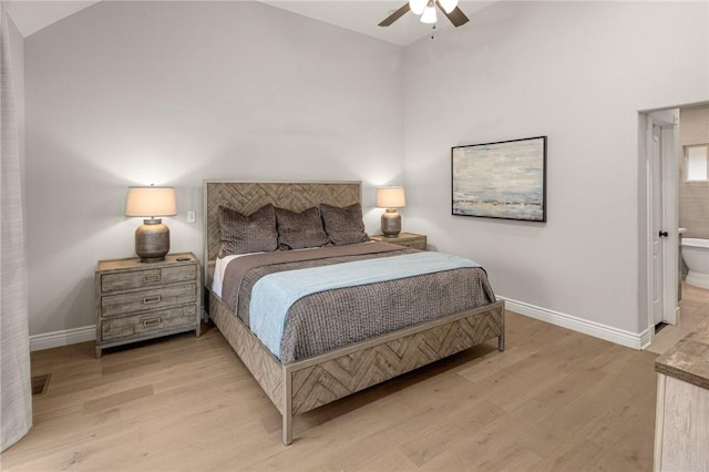 bedroom featuring light wood-style floors, connected bathroom, baseboards, and high vaulted ceiling