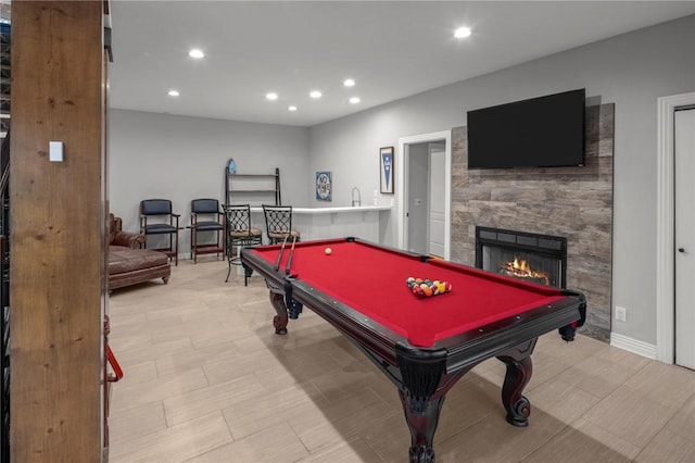 game room featuring recessed lighting, billiards, baseboards, and a warm lit fireplace