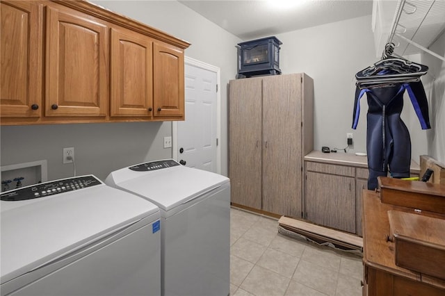 washroom featuring light tile patterned floors, independent washer and dryer, and cabinet space