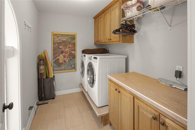 clothes washing area with cabinet space, separate washer and dryer, baseboards, and light floors