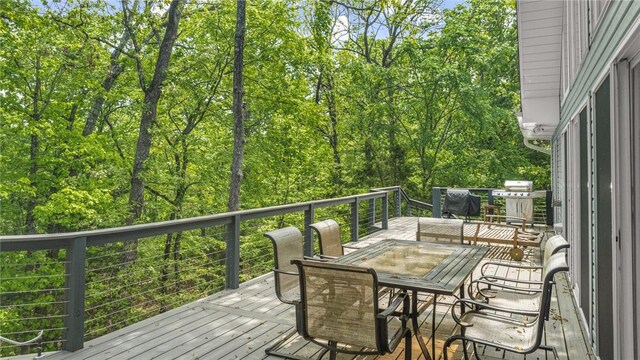wooden terrace with outdoor dining space and a grill