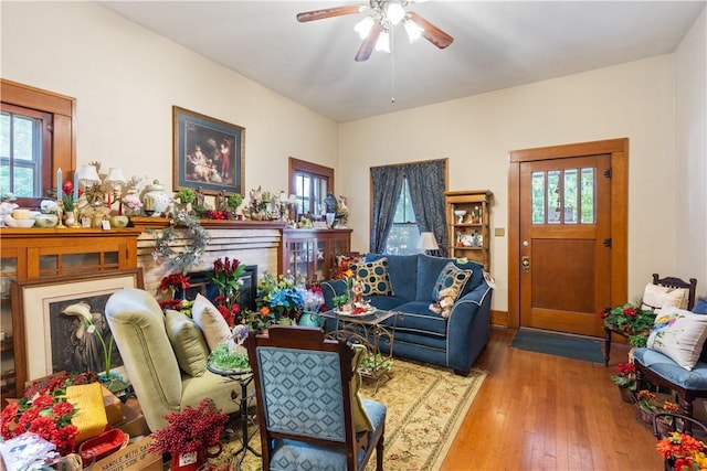 living area with hardwood / wood-style flooring, a fireplace, and a ceiling fan