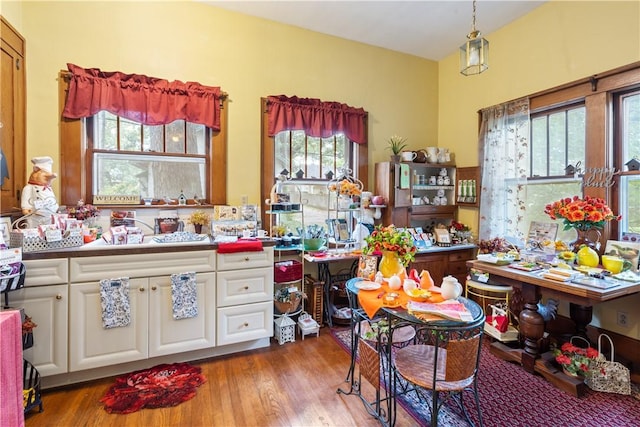 kitchen featuring hanging light fixtures, white cabinets, and wood finished floors