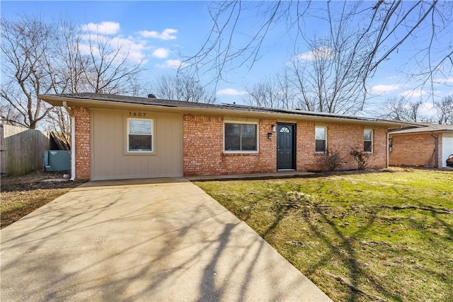 single story home with concrete driveway, brick siding, a front yard, and fence