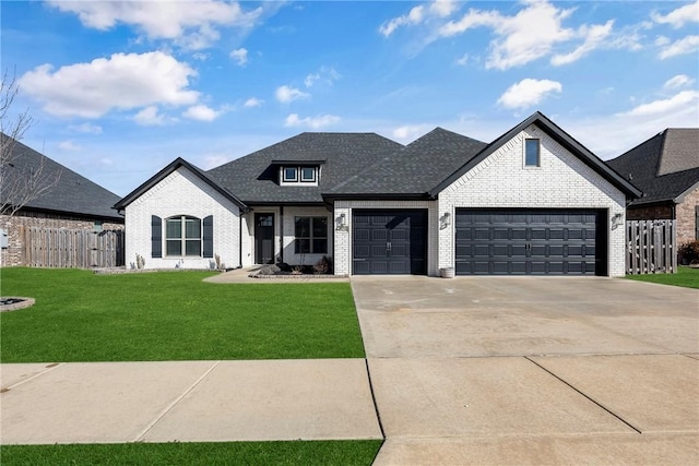 french country style house with concrete driveway, brick siding, an attached garage, and a front yard