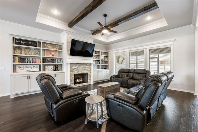 living room with baseboards, a raised ceiling, dark wood-style flooring, and a stone fireplace