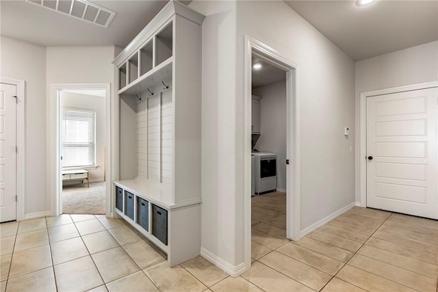 mudroom featuring light tile patterned floors, visible vents, washer / dryer, and baseboards