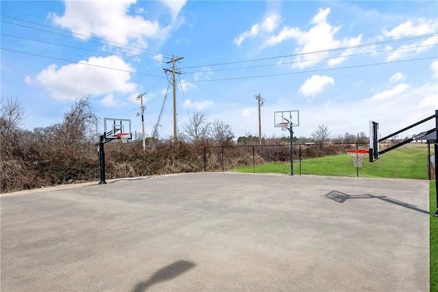 view of basketball court featuring community basketball court, fence, and a lawn