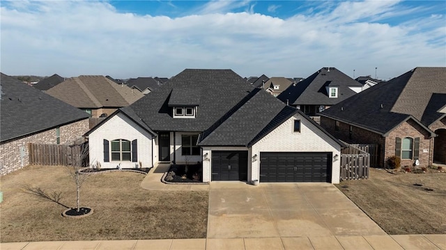 french country home with a garage, concrete driveway, a residential view, fence, and brick siding