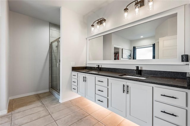 bathroom featuring double vanity, tile patterned floors, a sink, and a shower stall