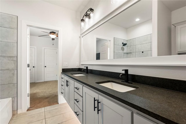 full bath with ceiling fan, a sink, a tile shower, and double vanity