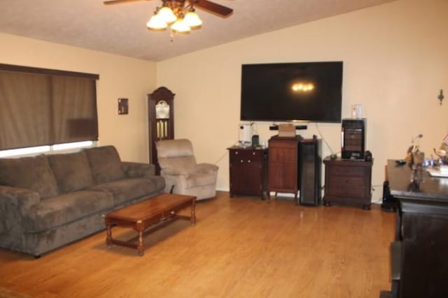 living room featuring lofted ceiling, ceiling fan, and wood finished floors