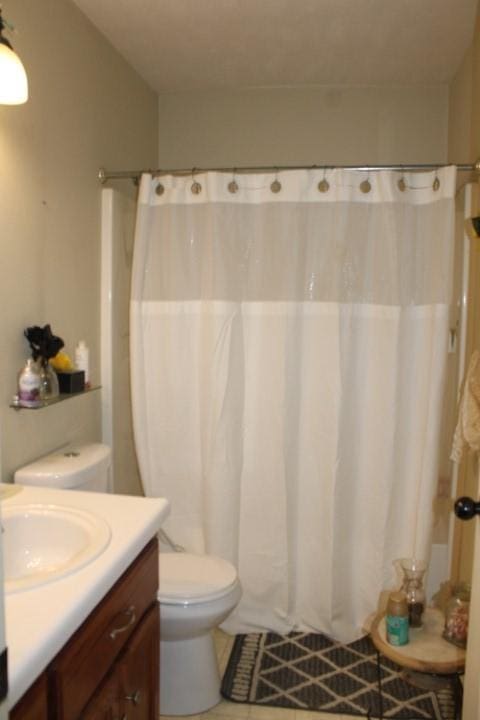 full bath featuring toilet, curtained shower, tile patterned flooring, and vanity