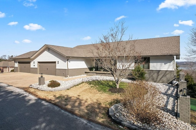 ranch-style home with a garage, brick siding, driveway, and roof with shingles